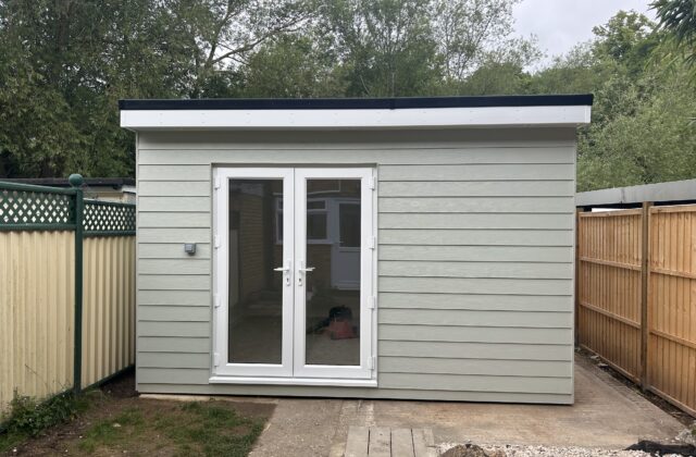 Bespoke garden room in Sawston with ivory hardie board cladding, white UPVC french doors, white fascias and an EPDM flat roof