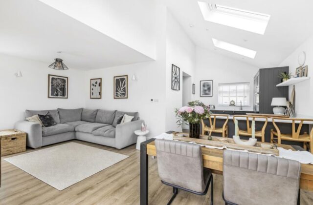 Open-plan living, dining and kitchen in the Waterbeach extension, with a dramatic vaulted ceiling, Velux skylights, dark grey shaker cabinetry and wood-effect LVT flooring