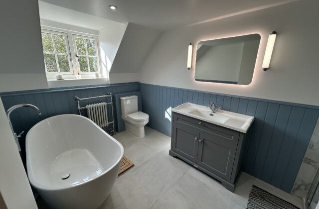 Cottage-style bathroom refurbishment in Newmarket with slate-blue wall panelling, a freestanding oval bath and floor-mounted chrome mixer tap
