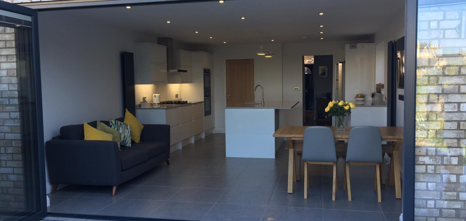 Open-plan kitchen and dining space in the Royston extension seen through full-width anthracite bifold doors
