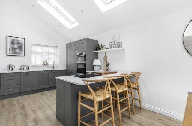 Multi-level breakfast peninsula with integrated seating under Velux skylights in the Waterbeach extension