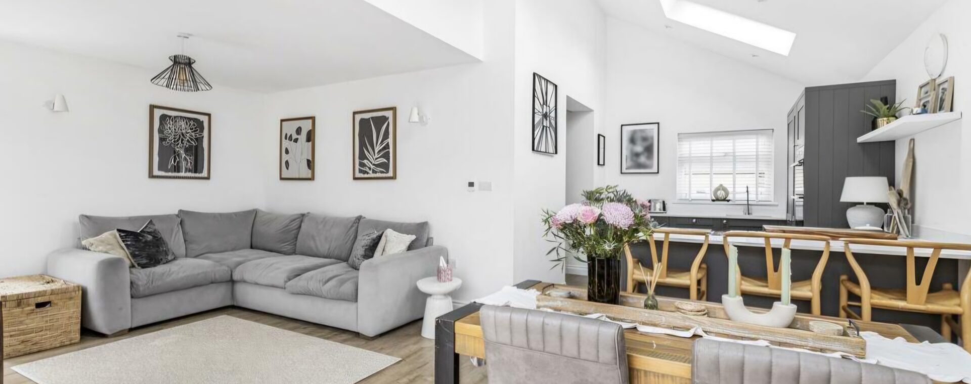 Open-plan living, dining and kitchen in the Waterbeach extension, with a dramatic vaulted ceiling, Velux skylights, dark grey shaker cabinetry and wood-effect LVT flooring